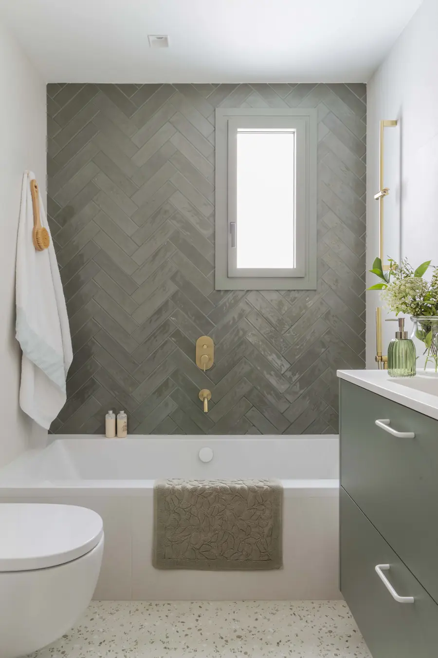 Un baño compartido con una nota de color Baño compartido con revestimiento verde en espiga y mueble lavabo a medida