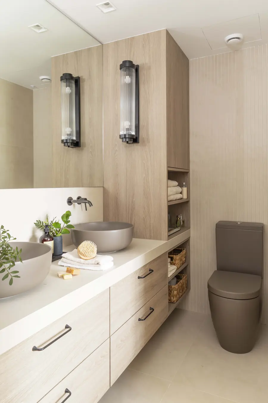 Un baño principal en una paleta de tonos arena Baño de la suite con doble lavabo, madera clara y tonos arena