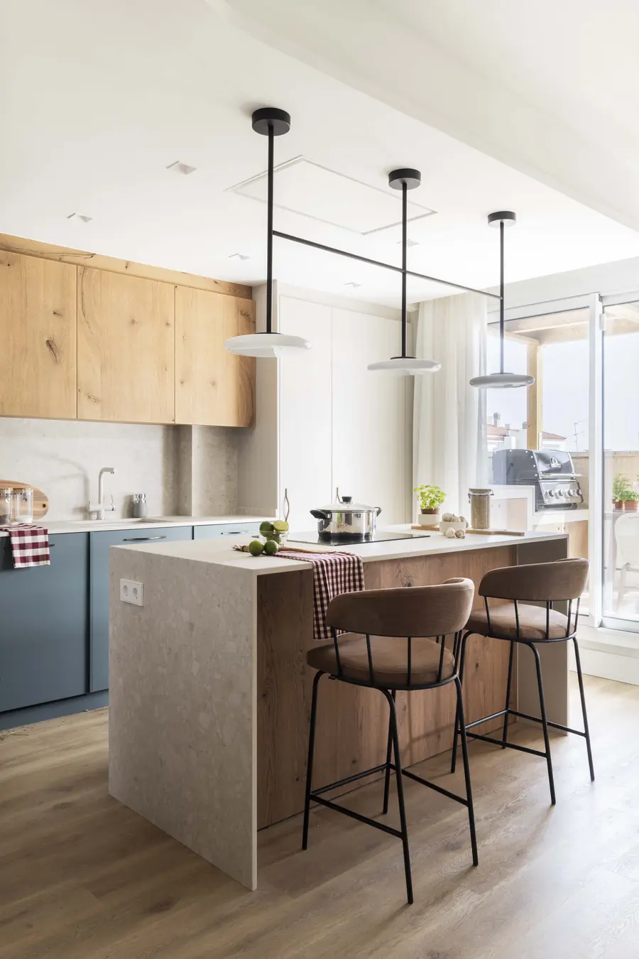 Una cocina verde abierta a la zona de día Cocina con isla central y muebles inferiores verdes en el ático 505 Muntaner
