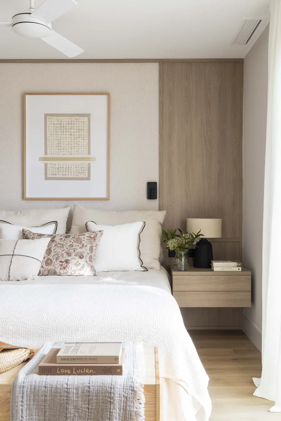 Una suite serena alrededor de un pilar integrado Suite principal con cabecero de madera, textiles claros y detalles negros