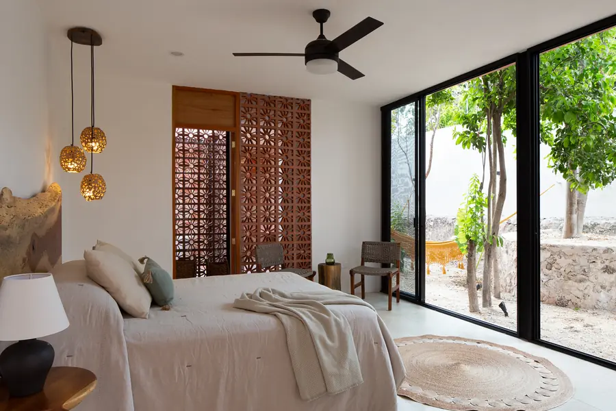 Dormitorio principal con vistas al patio Dormitorio principal de Casa Luciérnagas abierto visualmente al jardín