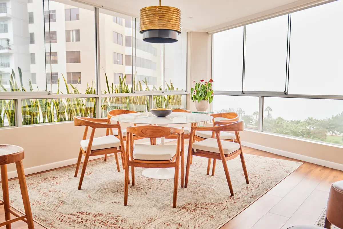 Comedor junto a los ventanales con vistas desde la vivienda de Malecón Cisneros