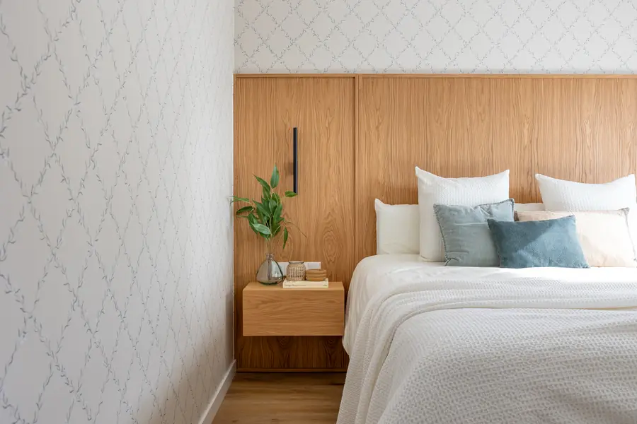 Dormitorio principal con cabecero de madera y papel decorativo