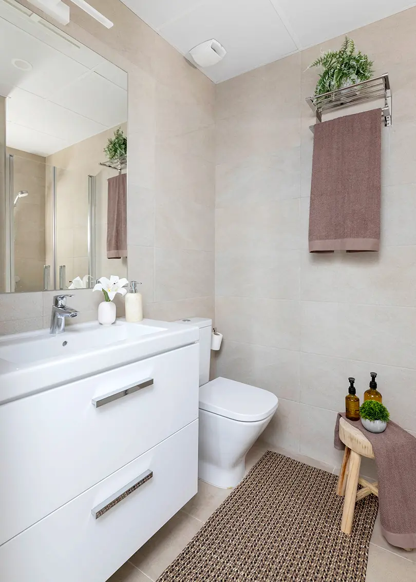 Un baño luminoso con mueble suspendido Baño con mueble suspendido blanco, espejo y revestimientos beige