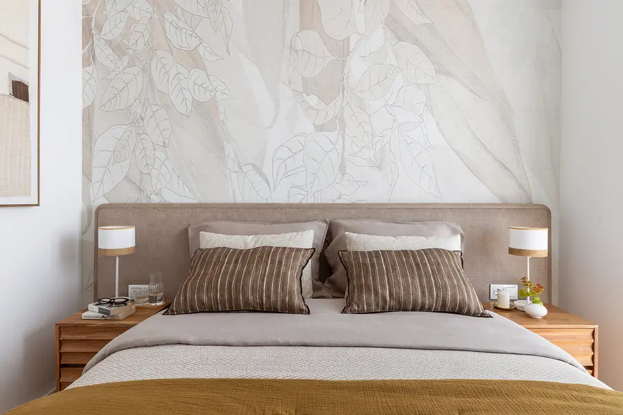 El dormitorio principal combina mural y cabecero tapizado Dormitorio principal con mural botánico, cabecero tapizado y textiles cálidos