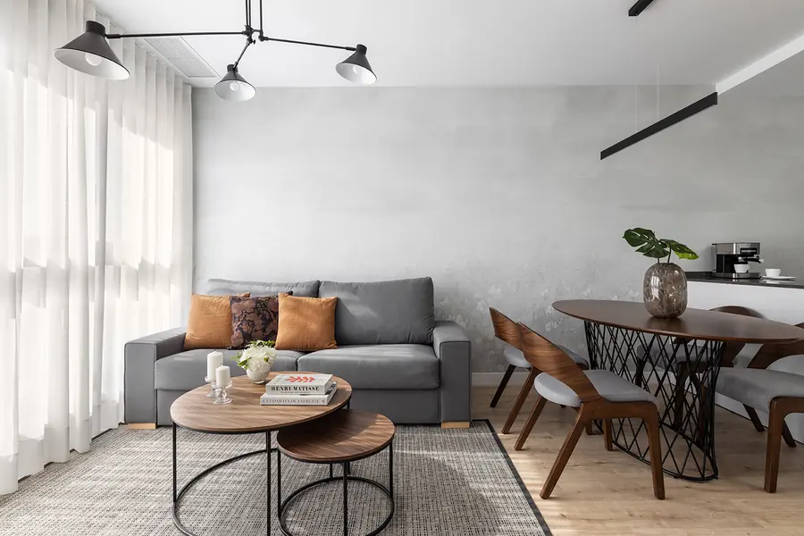Salón y comedor conectados junto al ventanal Salón y comedor abiertos con sofá gris, mesa redonda y ventanal