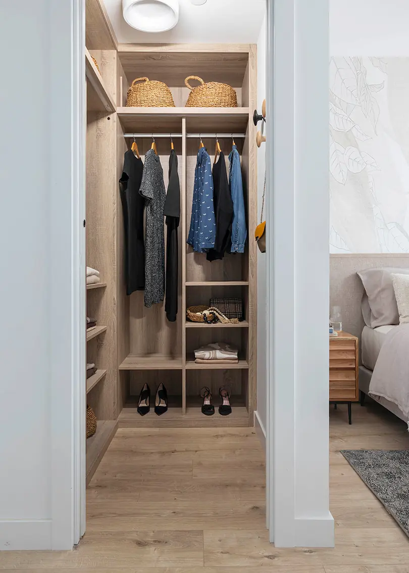 Un vestidor abierto aprovecha el espacio disponible Vestidor abierto con ropa y almacenaje de madera en Málaga Centro