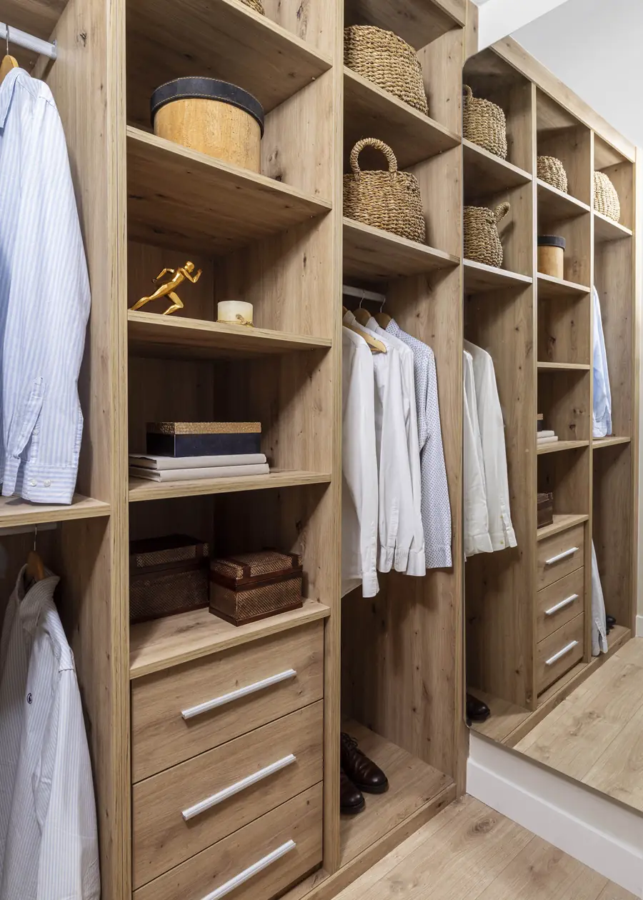 Almacenaje abierto y ligero en la suite Vestidor abierto con armario de madera integrado junto al dormitorio