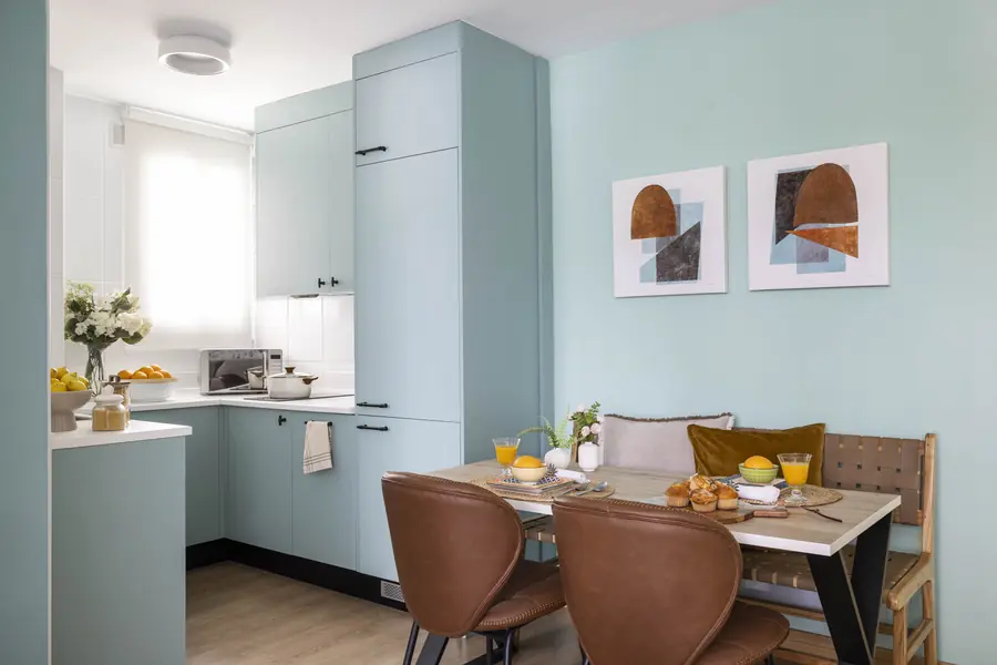 Cocina abierta y comedor con banco Cocina verde agua junto a un comedor con banco de madera y dos sillas