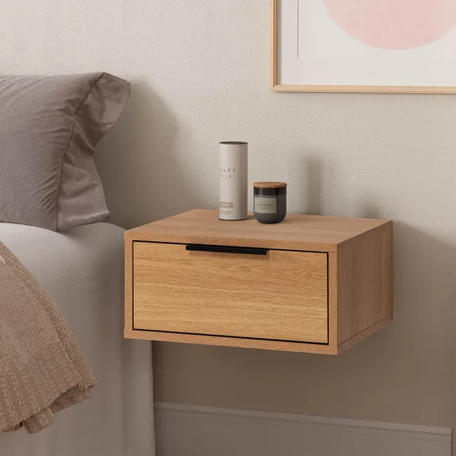 Mesita flotante Auri efecto roble en el dormitorio Mesita de noche flotante Auri efecto roble instalada junto a una cama