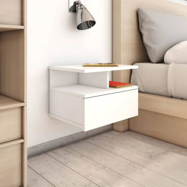 Mesita flotante blanca con cajón y estante junto a la cama Mesita flotante blanca con cajón y estante junto a una cama